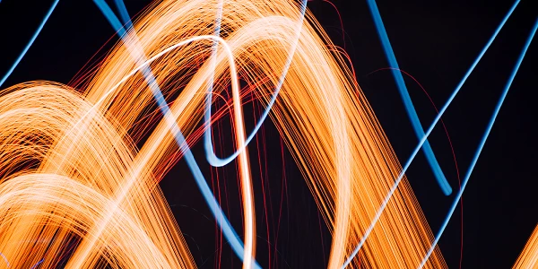 Orangefarbene und blaue Lichtspuren vor dunklem Hintergrund