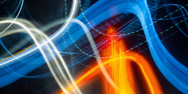 Interwoven light trails in blue, white and orange